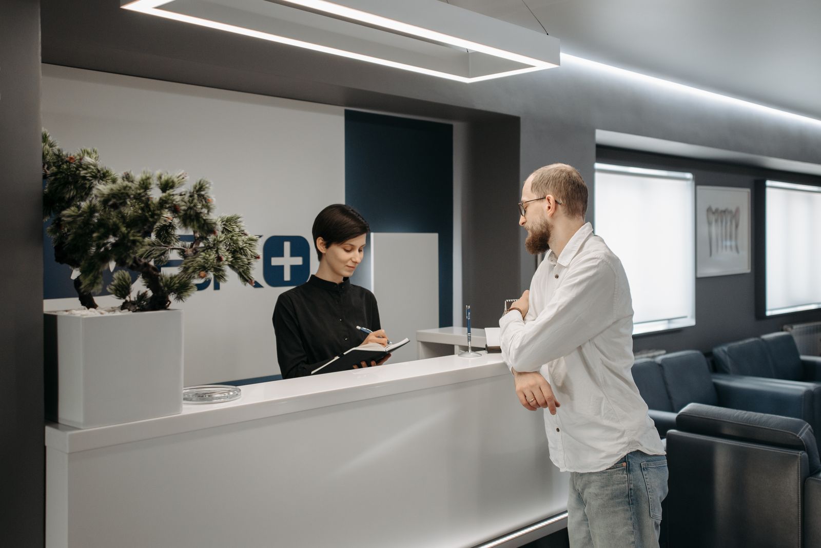 Paciente conversando com a recepcionista de uma clínica